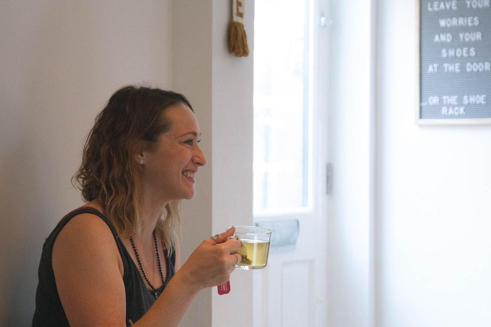 A smiling student holding a cup of tea in the studio lounge