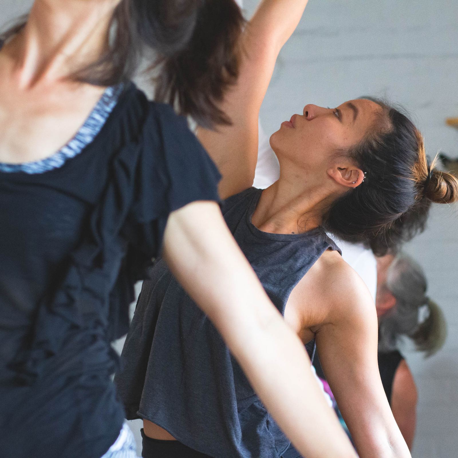 Students in a strengthening yoga class, lifting through the chest with arms drawn back