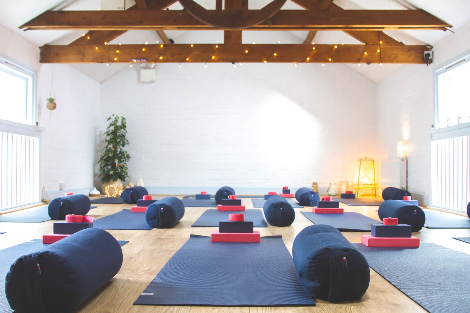 Studio Two, with exposed roof beams and mats laid out for class