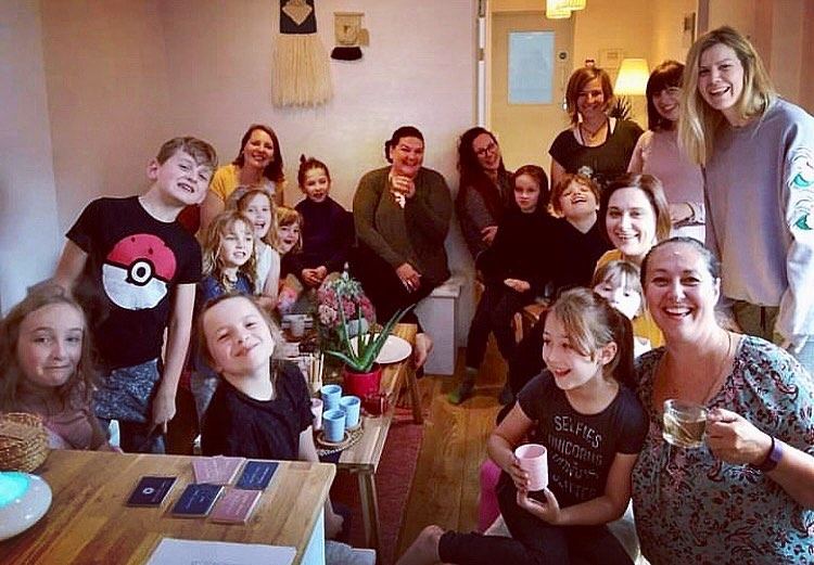 A happy group of children and parents gathered together in the studio, smiling at the camera