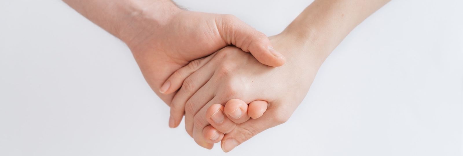 Two people holding hands in support
