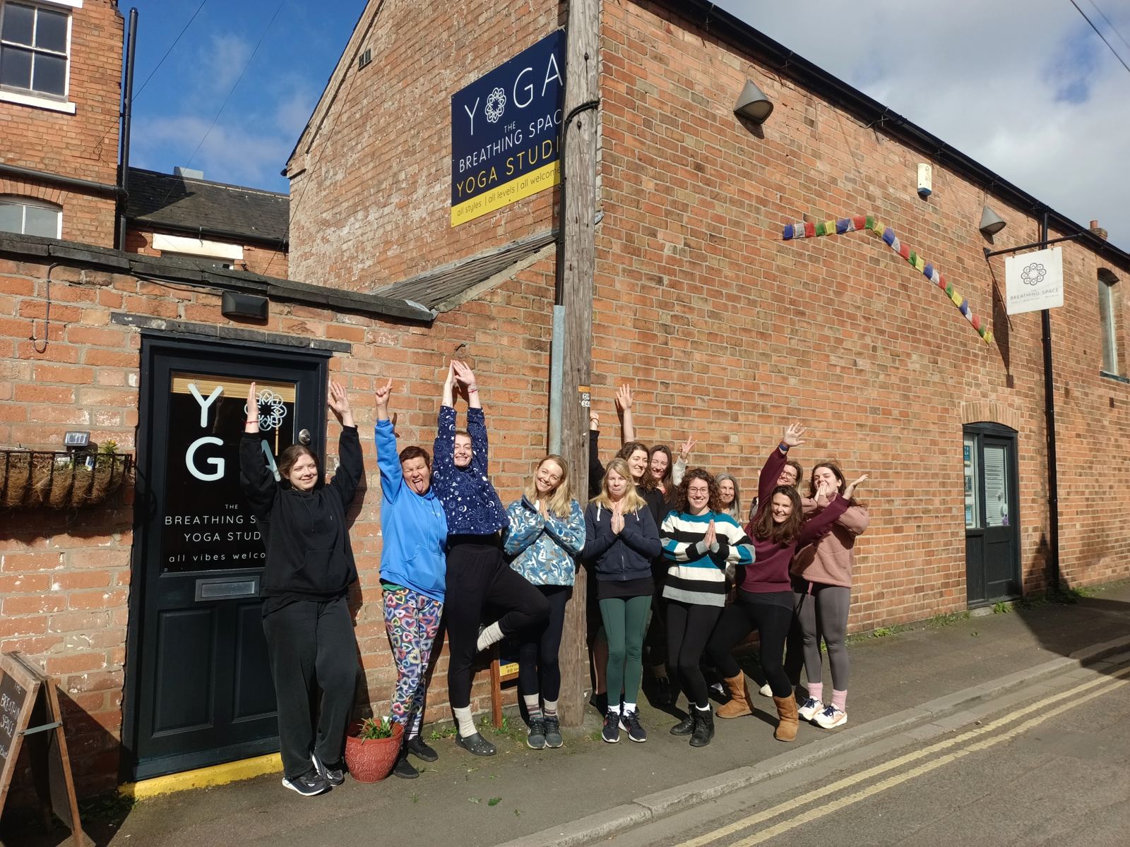 Students celebrating outside the brick Coach House
