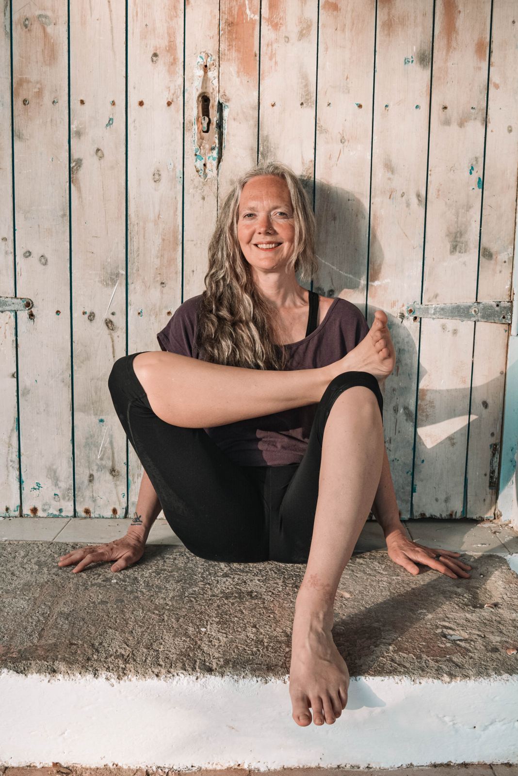 Melanie Cooper, our Yin trainer, sitting in half log fire pose