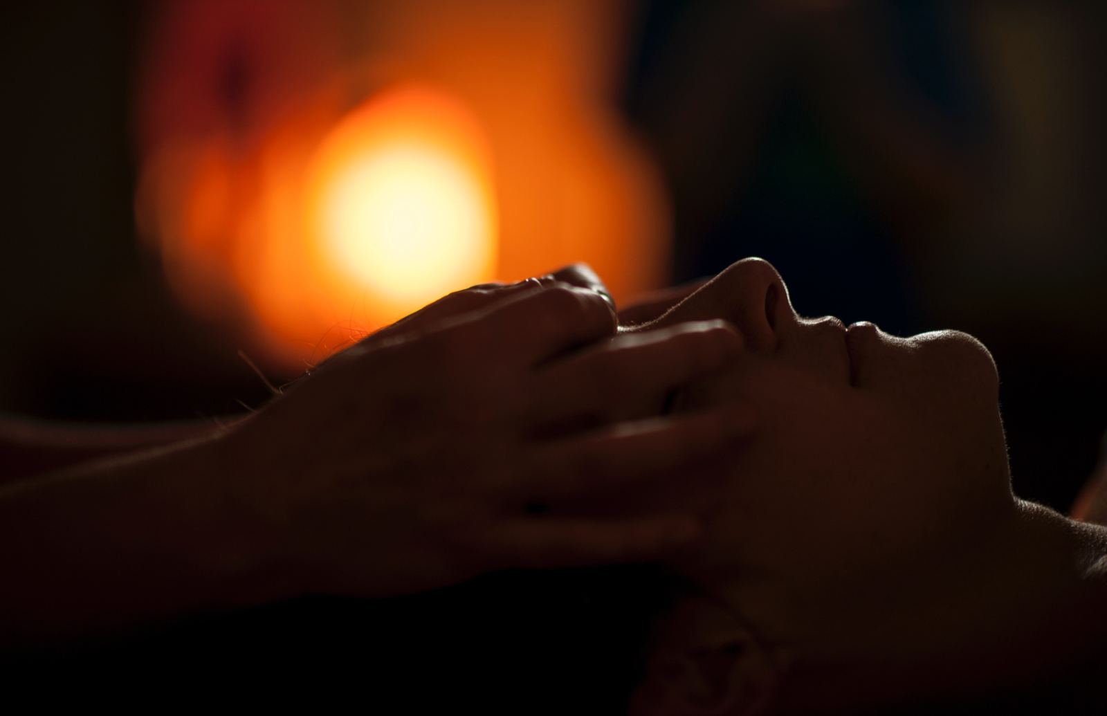 A reiki practitioner holding her hands above a client