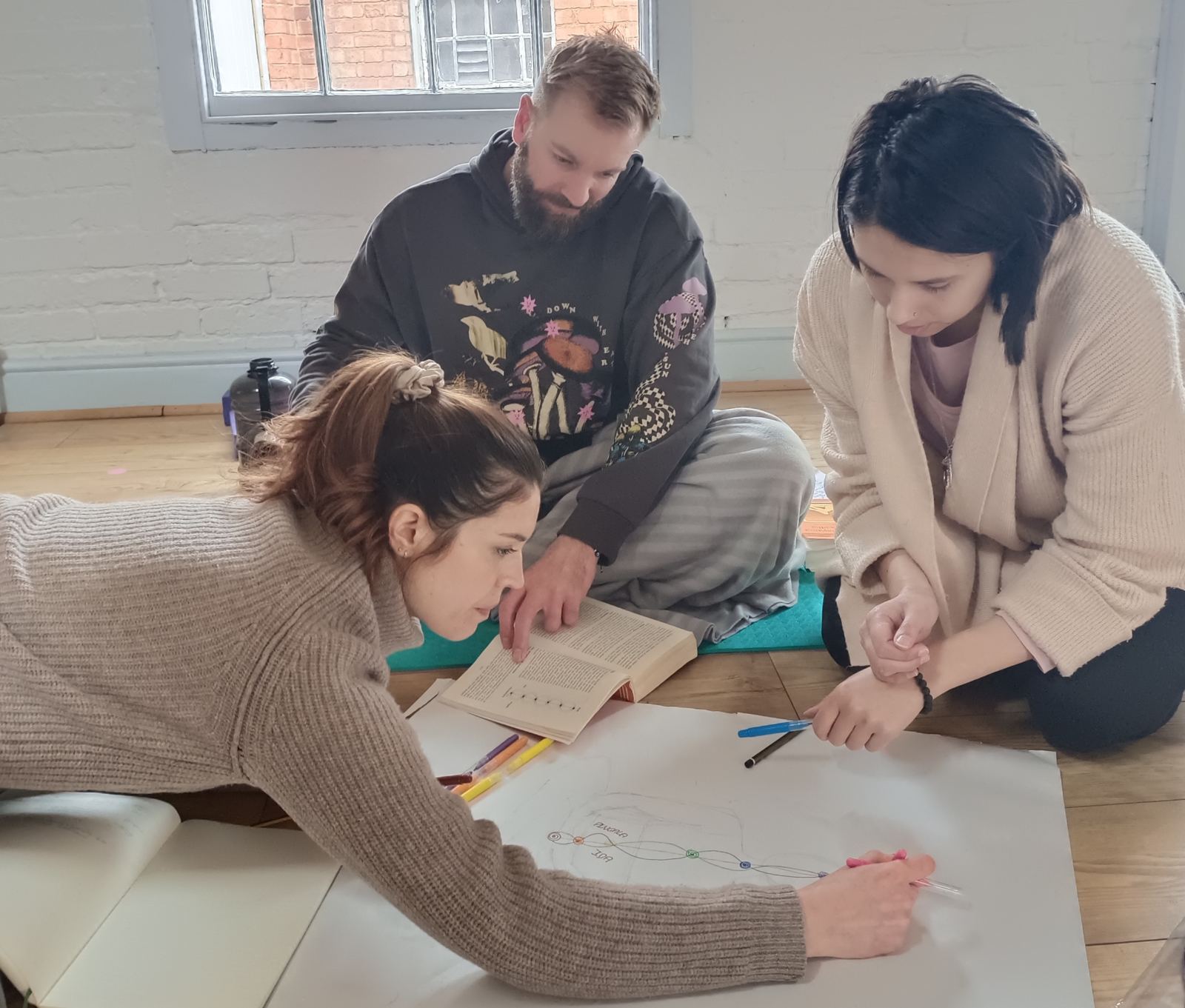 Teacher trainees working together on a group exercise on the studio floor